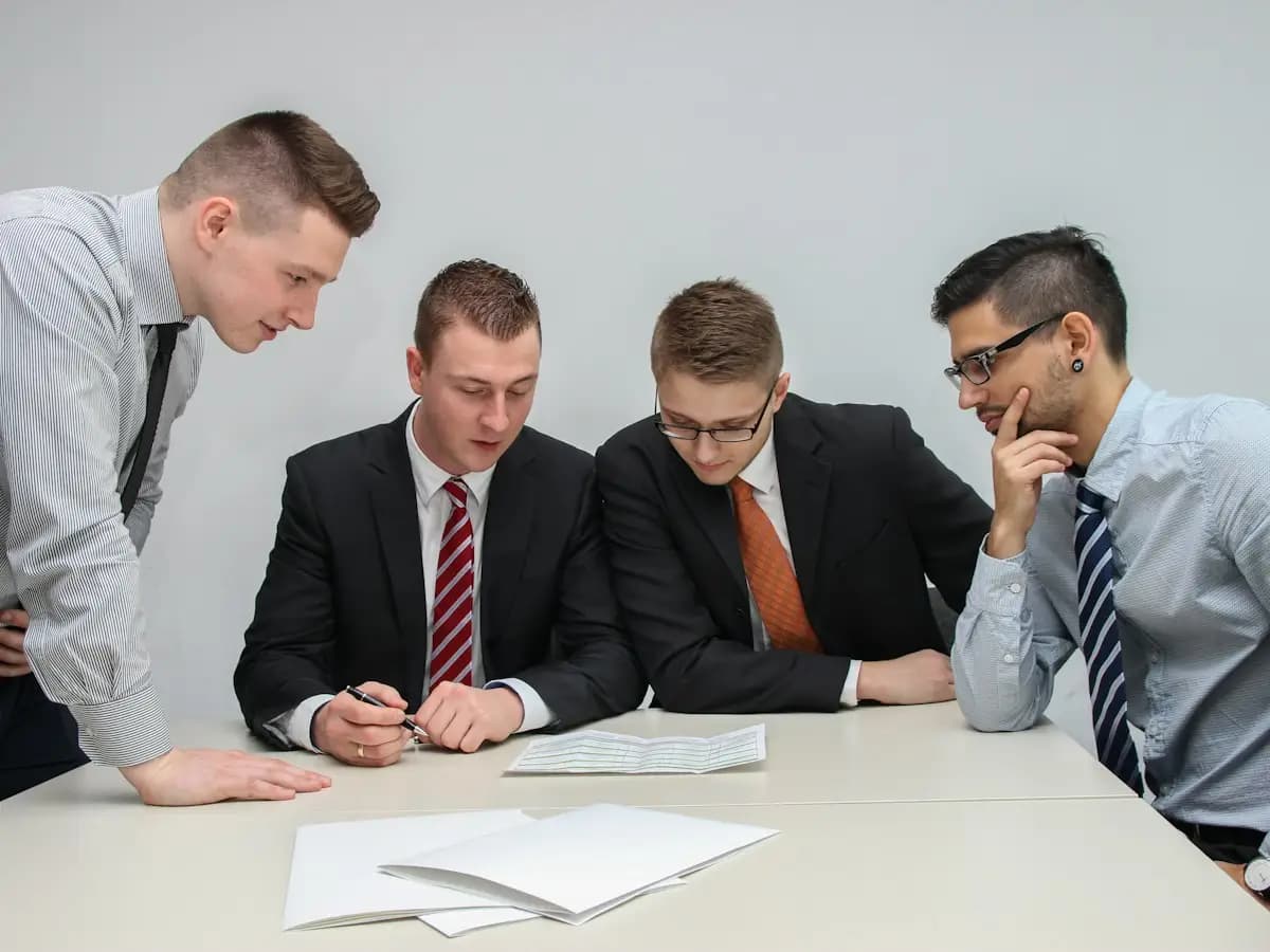 Beispielbild: vier Personen besprechen Unterlagen an einem Tisch